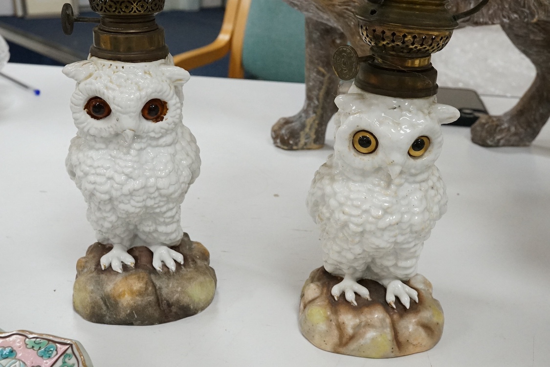 A pair of Paris porcelain oil lamps with white glazed porcelain stems modelled as owls (one lacking shade), 40cm high. Condition - fair